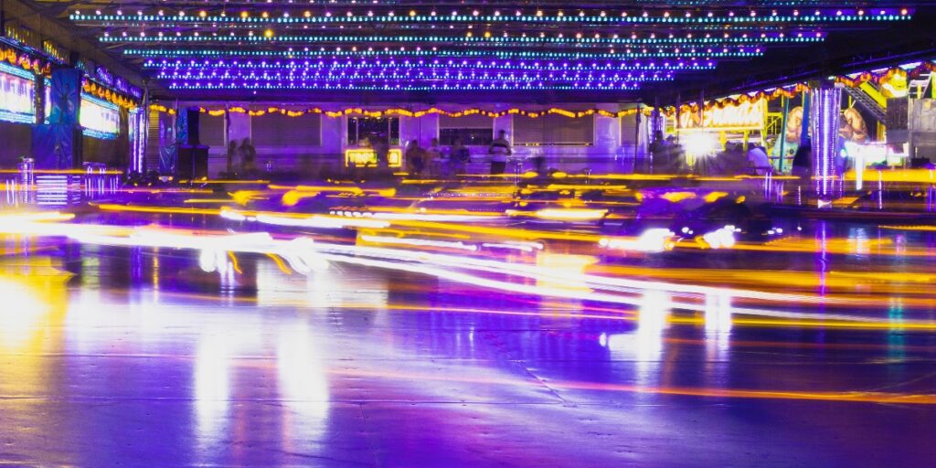 A picture of dodgems at a fairground surrounded by blurred fast light to represent speed reading