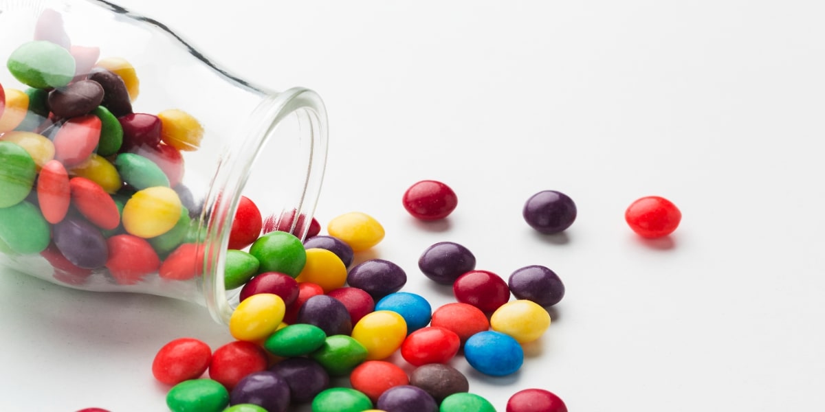 Sweets spilling from a jar as a comparison as a way of displaying how to clean up chemical spills in the lab