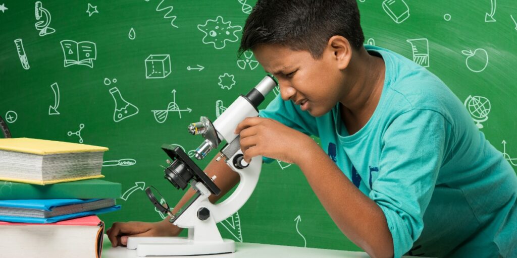 Image of a child looking puzzled at a microscope to represent uncertainty as to what histology fixatives are doing to samples.