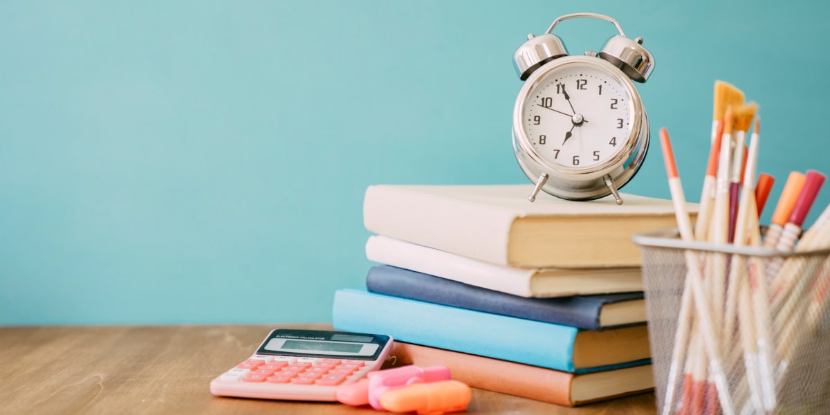 A clock on a stack of books to show how to read a scientific paper with limited time