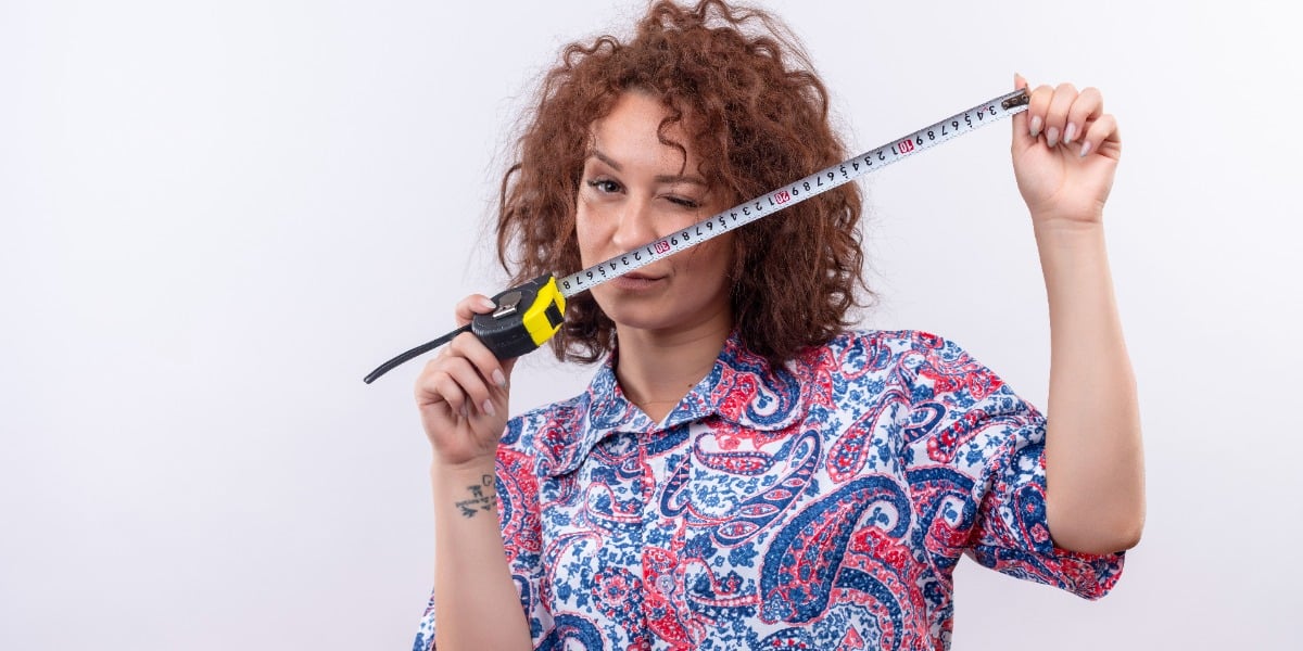 Woman with colorful shirt holding tape measure to represent how to measure FRET