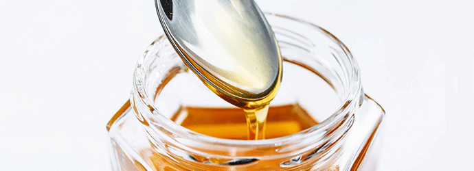 Golden Honey Pouring From The Spoon