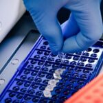 Scientist loading PCR tubes into a PCR machine to represent Ct values in PCR testing.