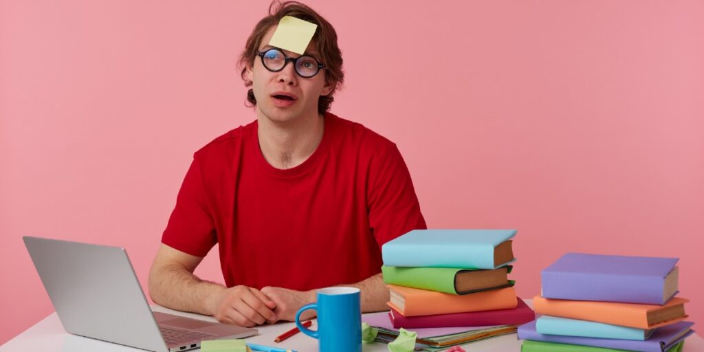 Image of man witch post-it on forehead, indicating the pain of creating a thesis outline