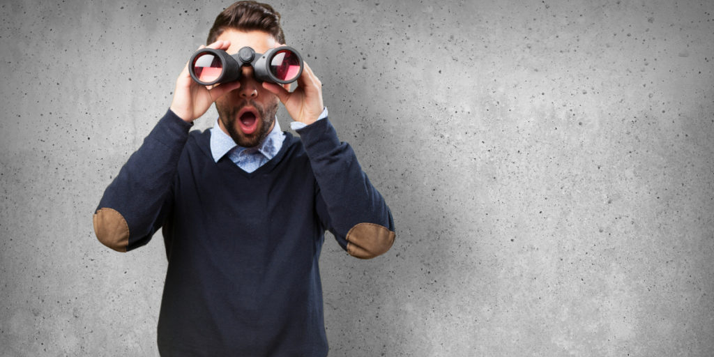 A picture of a man holding binoculars with a surprised expression to represent learning how to improve your PubMed searches