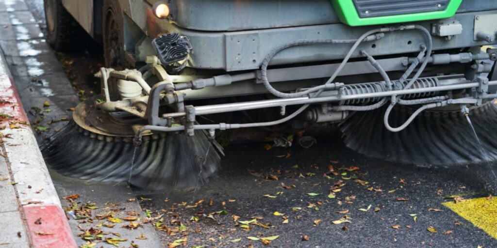 A street sweeper sweeping leaves from a road to represent DNA clean-up