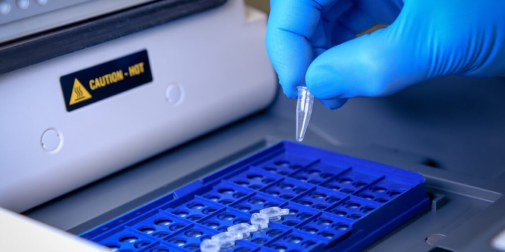 A gloved hand inserting PCR tubes into a thermocycler to represent answering the question how to get started with PCR