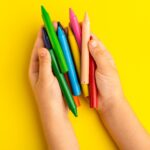 An image of a kid holding colorful pencils to depict using molecular visualization tools.