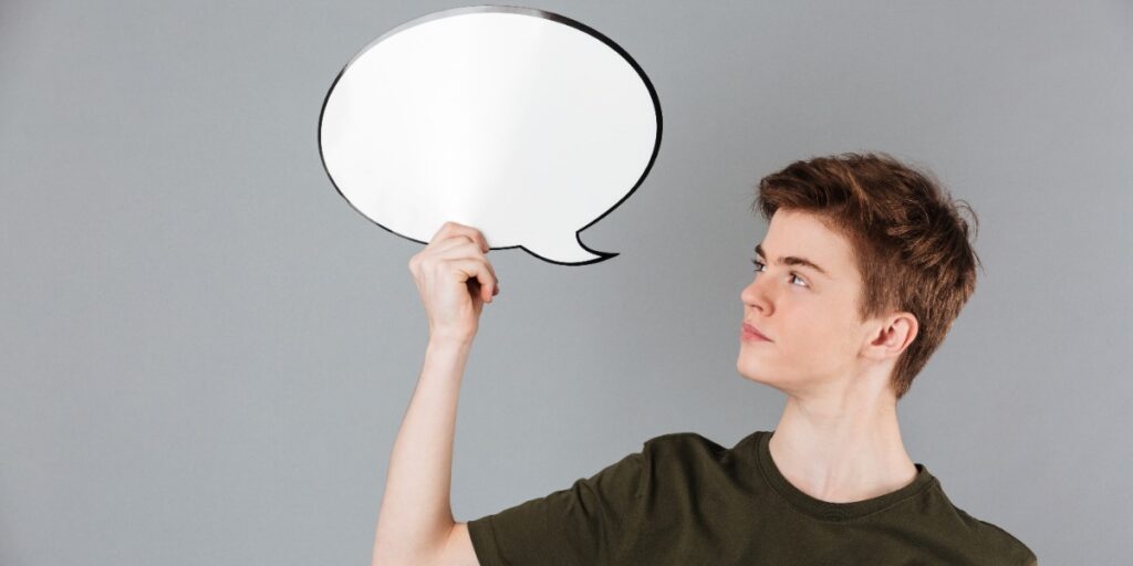 Image of a man holding up a speech bubble to indicate thesis writing tips like how to insert captions and a table of contents in Word