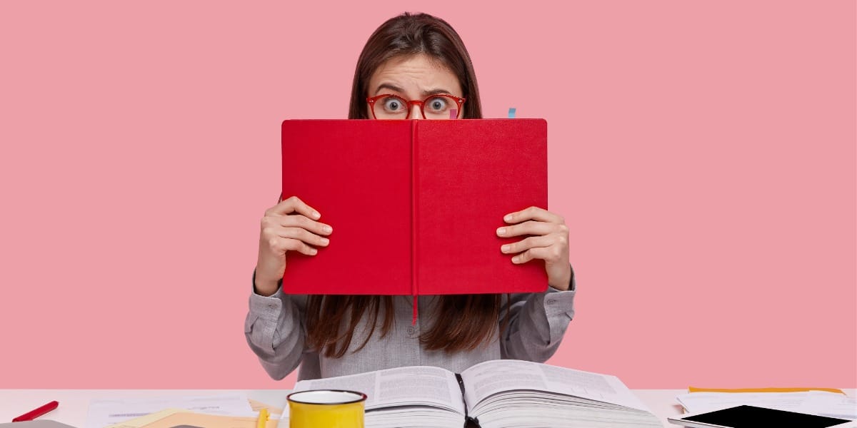 A woman with a large red textbook covering the bottom half of her face to represent the top features of ReadCube Papers for scientists