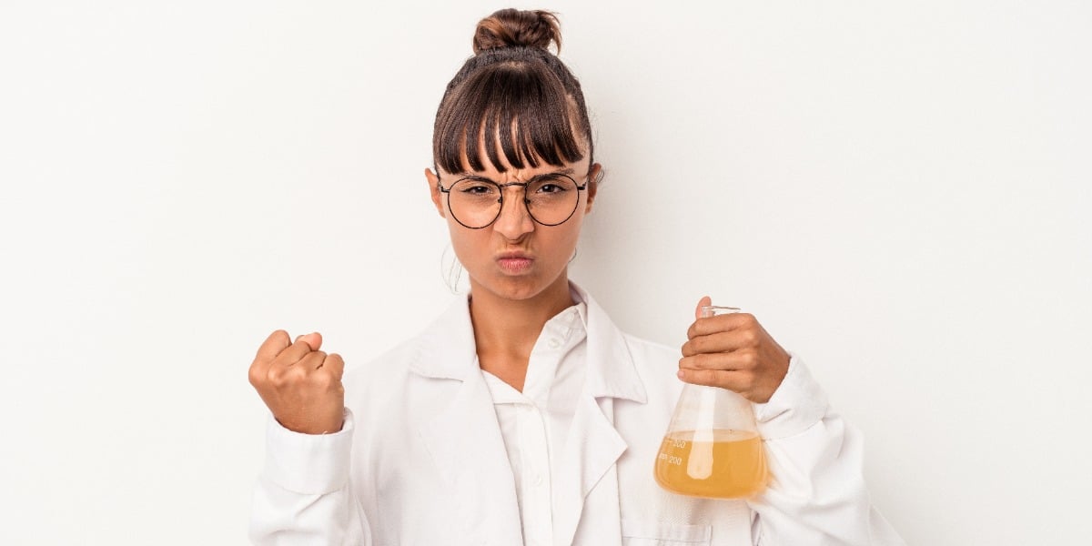 Scientist frustrated while holding a culture flask becasue of low plasmid yield