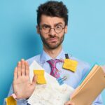 A man covered in notes and paper indicating under preparedness for journal club