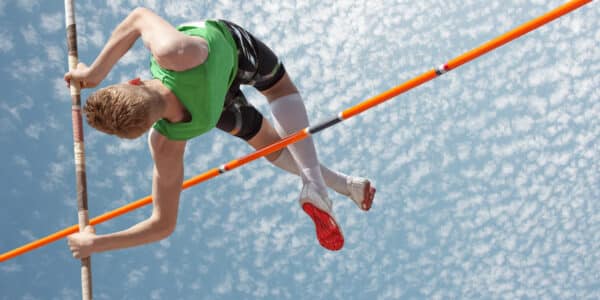Someone doing the high jump to represent agility and progress with agile project management