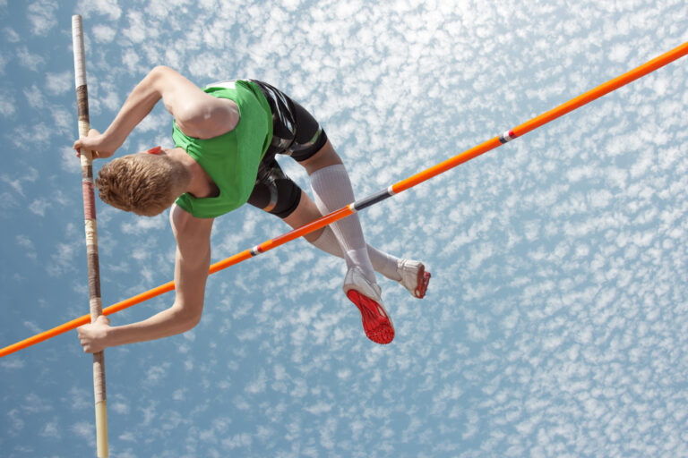Someone doing the high jump to represent agility and progress with agile project management
