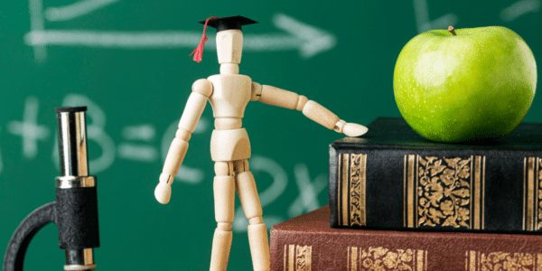 Wooden figure with apple and books