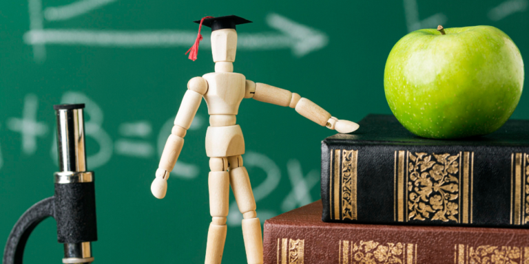 Wooden figure with apple and books