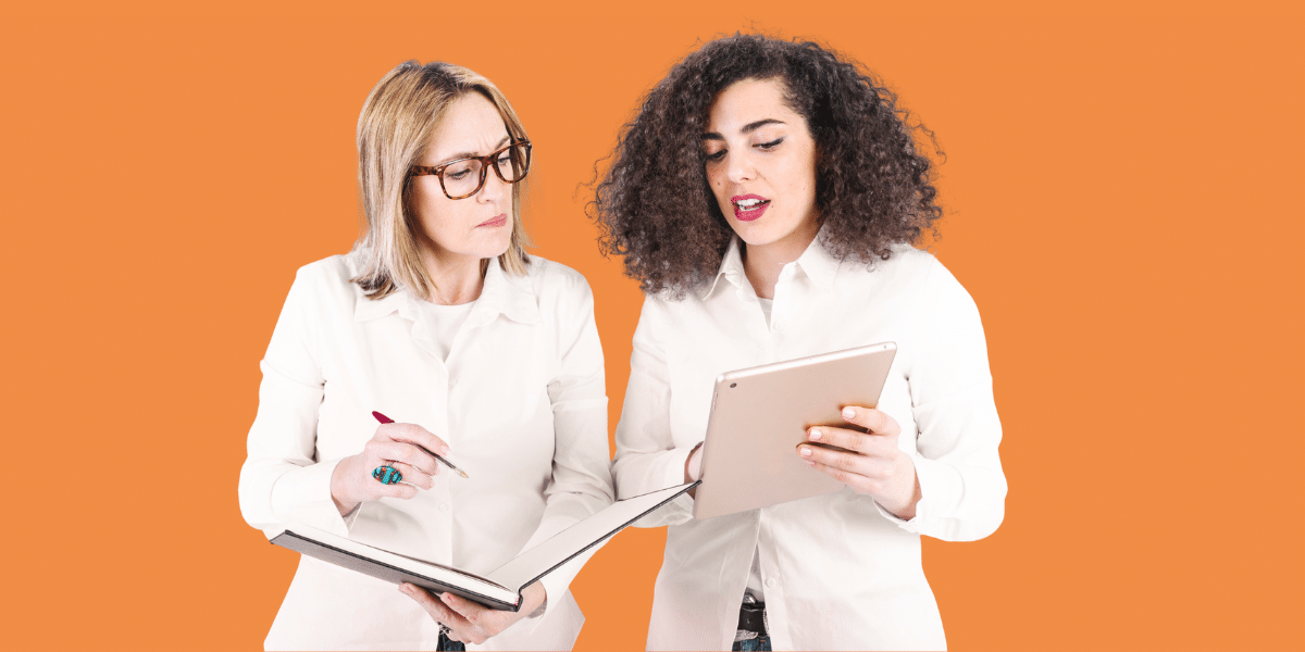Two women discussing with tablet and notebook