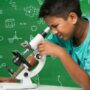 Image of a child looking puzzled at a microscope to represent uncertainty as to what histology fixatives are doing to samples.